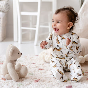 6 month old baby girl laughing, sitting up, wearing Molly Hare print babygrow
