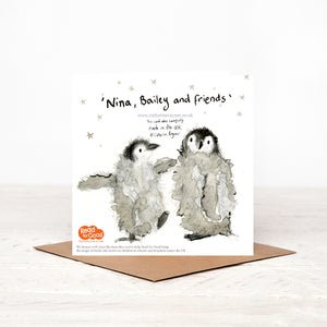 Christmas card stood on matching brown envelope, showing the reverse side of illustrated baby penguins Christmas card, featuring two more baby penguins surrounded by stars, alongside details of Christmas charity partner children's literacy charity Read for Good. 