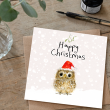 Load image into Gallery viewer, Christmas card with owl wearing a Santa hat on a wooden surface