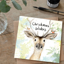 Load image into Gallery viewer, Christmas card with a deer illustration and &#39;Christmas Wishes&#39; text on a wooden surface.