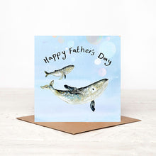 Load image into Gallery viewer, Father’s Day card with a whale and calf design placed on a bright wooden surface with a softly blurred white background and natural lighting.