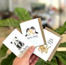 Load image into Gallery viewer, Three small greeting cards with animal illustrations held by a hand, blurred indoor background