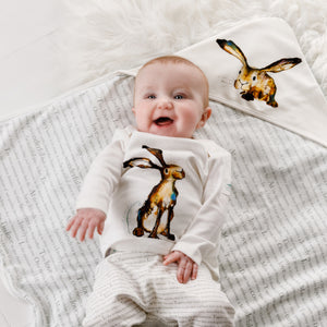 Baby wearing Molly hare t-shirt lying on Molly hare baby wrap blanket