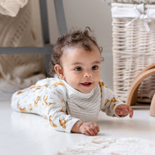 Load image into Gallery viewer, six month old baby wearing the bib with the story printed side facing out, and an olive owl babygrow. She is crawling towards us, smiling