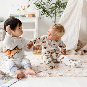 Two toddlers sitting together wearing the Dexter fox print top, joggers and babygrow