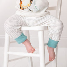 Load image into Gallery viewer, Close up of baby sat on a white chair wearing storytime joggers with ocean blue cuffs. 
